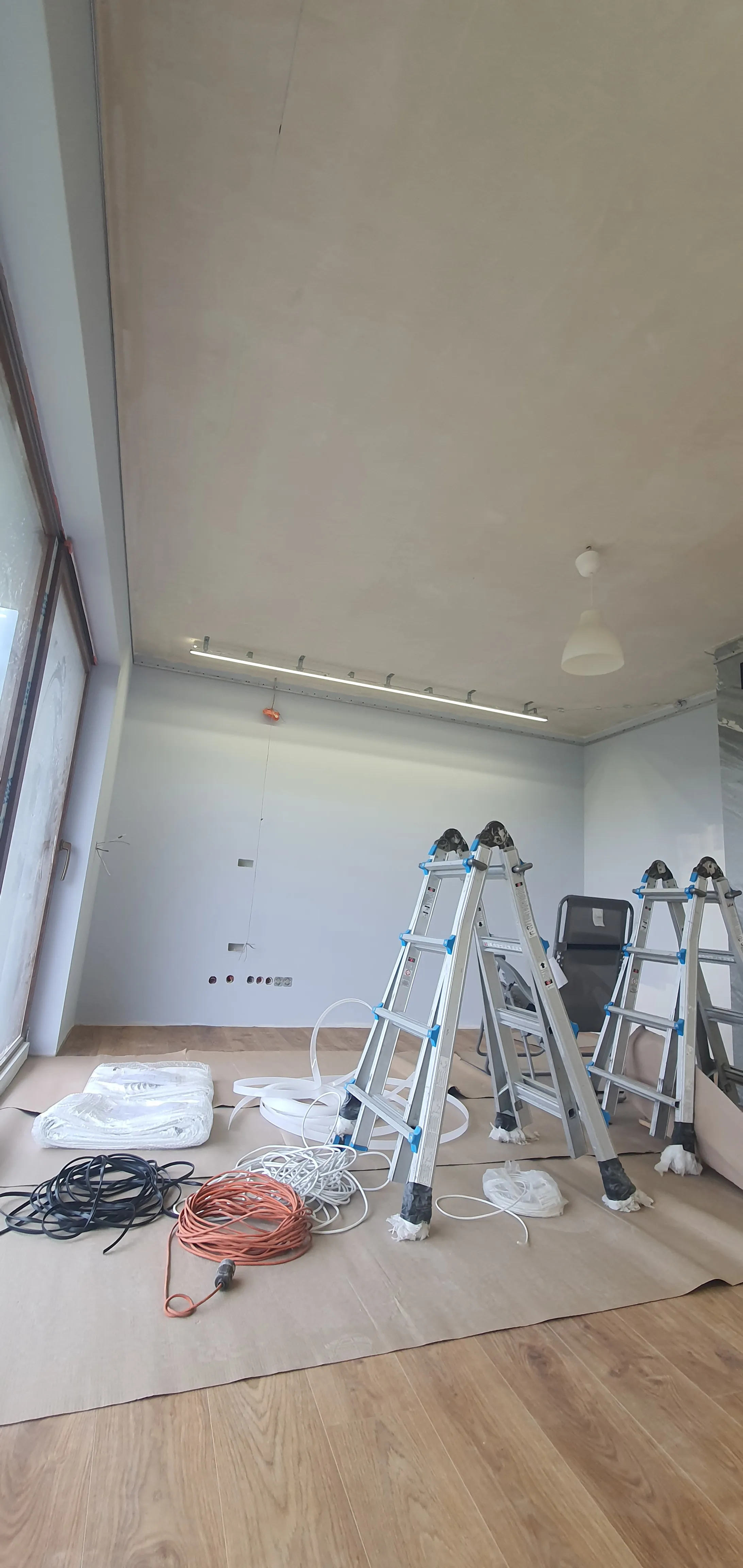 Specjalista mierzący laserowo pomieszczenie pod montaż sufitu napinanego w Radomiu